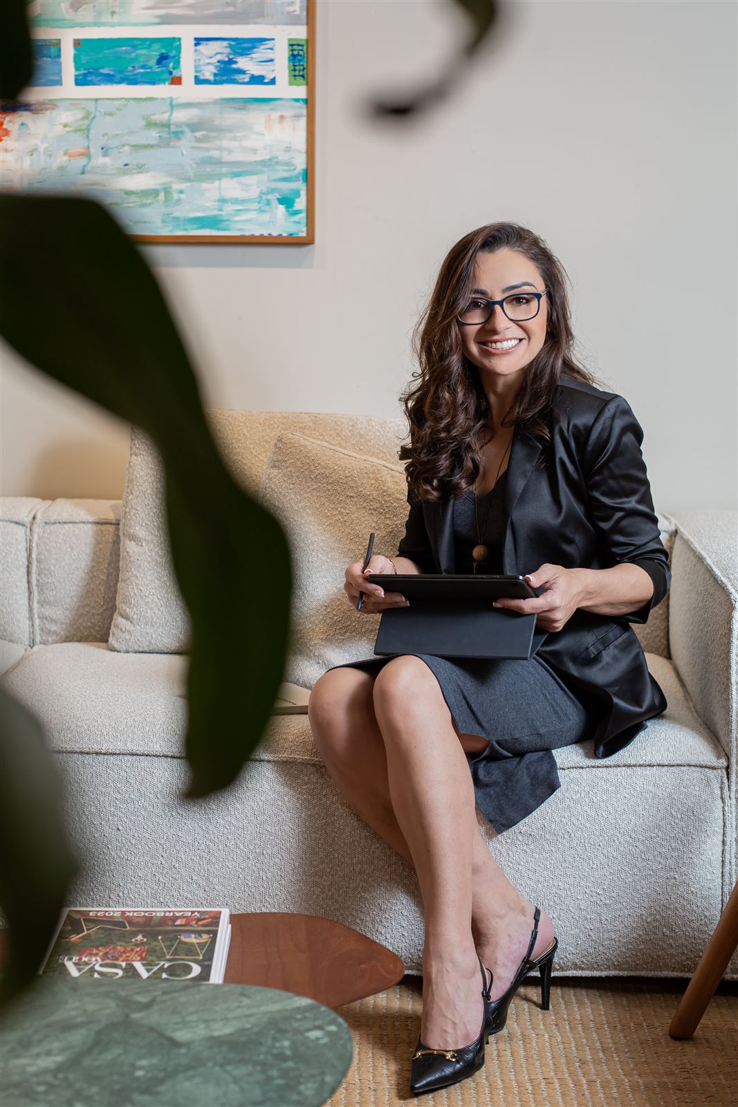 Cristina Gravina sentada com tablet em ambiente de trabalho